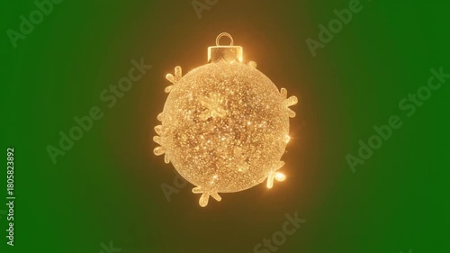 A glowing golden Christmas ornament with snowflake accents is suspended against a vibrant green background, perfect for holiday-themed designs.