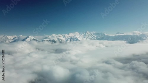 Aerial view from above of clouds. Rosa Khutor Ski Resort, mountains covered by snow in Krasnaya Polyana, Russia.