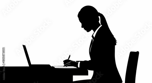 Silhouette of a woman in a suit working on a laptop and writing.
