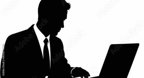 Silhouette of a businessman working on a laptop computer.