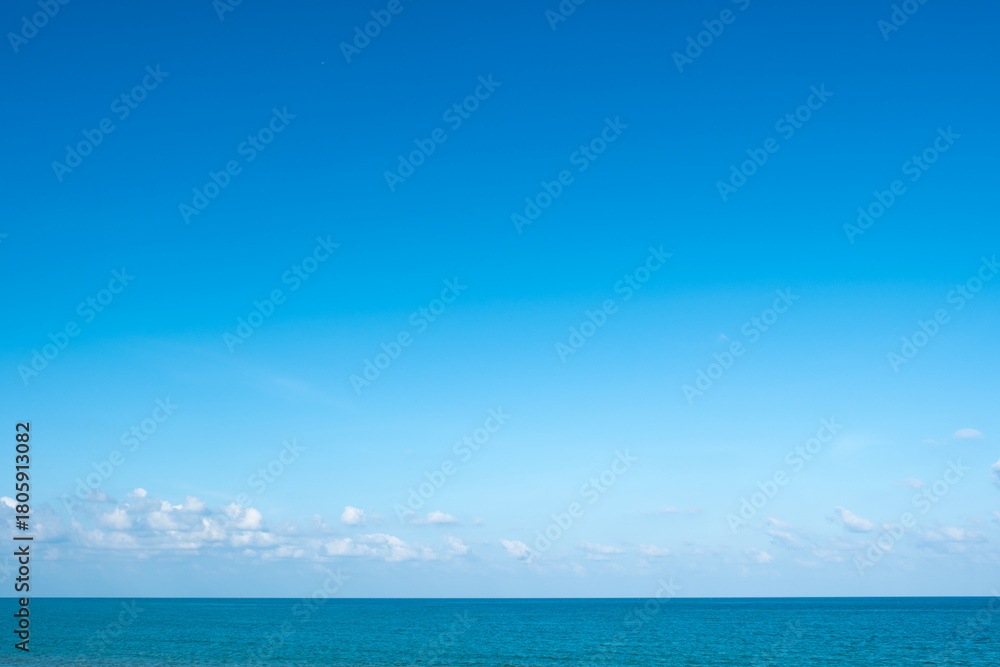 Obraz premium Nature of the ocean and blue sky Summer with sunshine, sandy beaches, clear blue waters sparkling against the blue sky. on an island with good ecology and environment Background for summer vacation