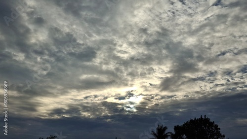 the sky is covered with dark clouds in the mroing or evening, and the sunlight shines through the clouds, creating a dimension of light and shadow