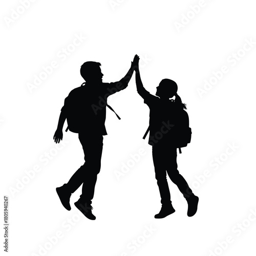 Two joyful students with backpacks giving a high five silhouette