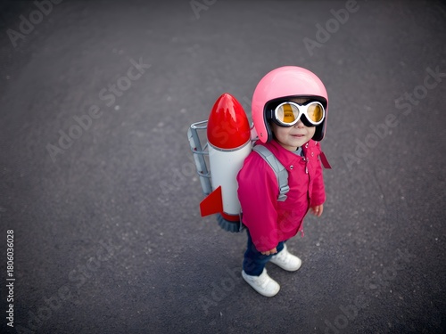 Child in pink astronaut helmet and jetpack ready for adventure