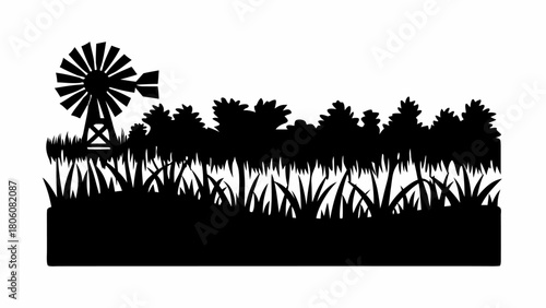 Charming country landscape silhouette with windmill, grassy field, and trees in a rural setting