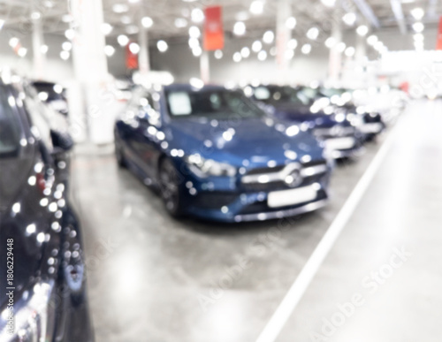 Blurred background with car dealership store interior. Blurred abstract dealership store with defocused cars. Blur bokeh transportation concept dealer showroom