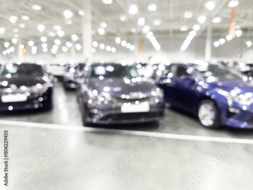 Blurred background with car dealership store interior. Blurred abstract dealership store with defocused cars. Blur bokeh transportation concept dealer showroom