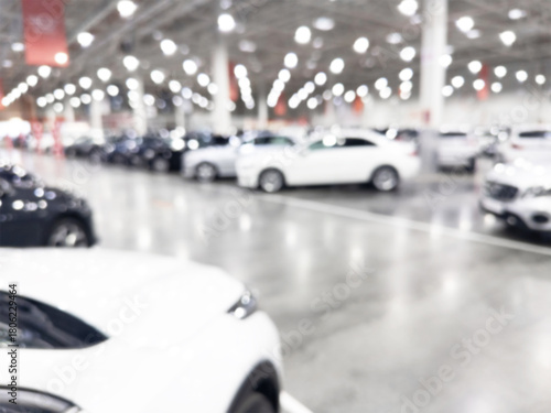 Blurred background with car dealership store interior. Blurred abstract dealership store with defocused cars. Blur bokeh transportation concept dealer showroom