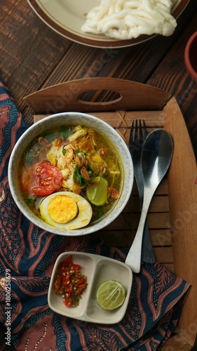 Soto ayam or chicken soto, Indonesian food on the table with sambal.