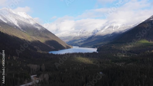 Stunning Aerial View of a Lake Nestled Between Snow-Capped Mountains and Dense Forest in British Columbia, Canada