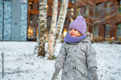 Portrait of a girl child wearing a hat in winter in a snow park