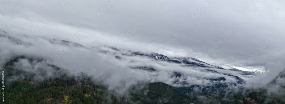 Fototapeta premium Misty Mountain Range in Clouds Over Forested Valley in British Columbia, Canada