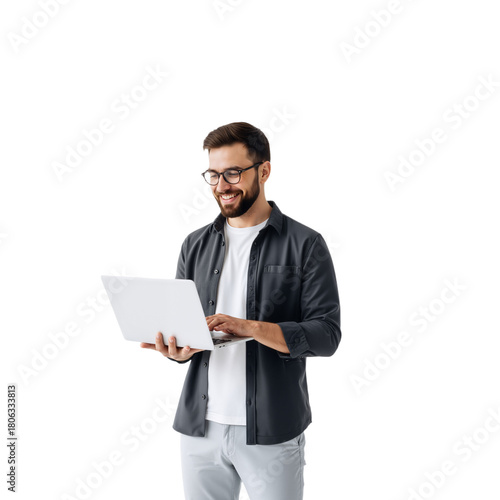 Cheerful Young Professional with Laptop: Dark Curly Hair, Glasses, and Grey Layered Attire Against White Background — Fully Engaged, Smiling While Typing, Radiating Creative Energy, Modern Productivit