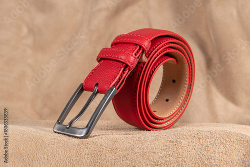 Men's model leather belt. Red men's belt on leather base.
