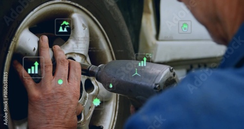Stabilizing wheel hub and operating impact wrench in workshop, wearing blue shirt with AR overlays