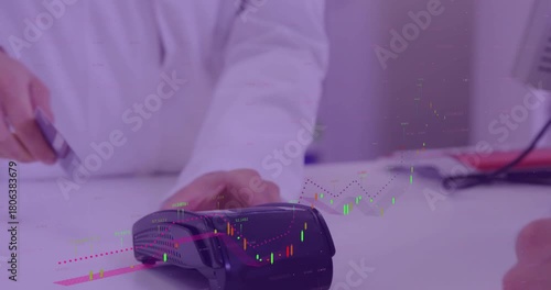 Customer extending card, staff running card through terminal, completing retail payment at counter