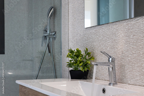 Modern bathroom sink with running water and chrome faucet