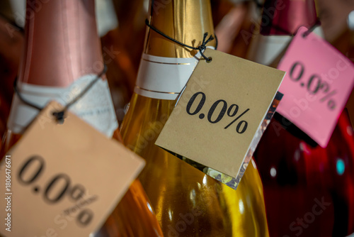Paris, France - 11 19 2025: Detail of the neck of three bottles of rosé, white and red wine with a 0.0% alcohol-free label in a store