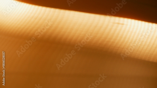 Orange background of hard paper and abstract diagonal shadow. Abstract background of orange paper texture. Lines, artistic, minimalist, natural light, summer tone concept for texture, cover, display. 