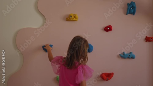 Rock climber girl at rock climbing wall at home, pink climbing wall for girls, activity for kids at home, active life