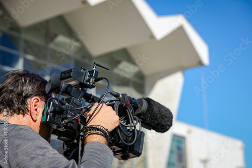 Professional cameraman, videographer is filming with camera for live broadcast