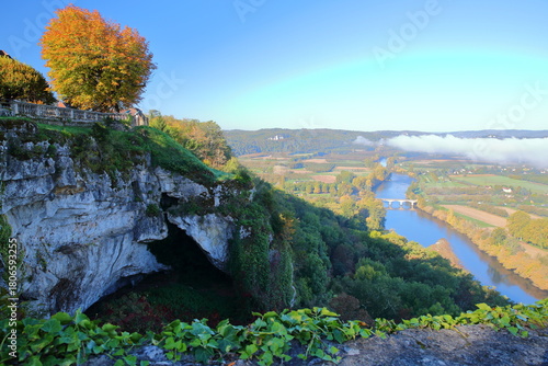 The esplanade of the medieval village Domme, Dordogne, France, overlooking the river Dordogne and its countryside, with autumn colors and morning mist
