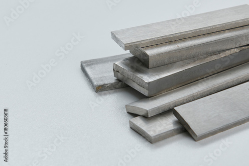 High quality close up image of stainless steel metal bars and flat sections with smooth industrial texture, suitable for construction, engineering, manufacturing, and industrial design concepts.