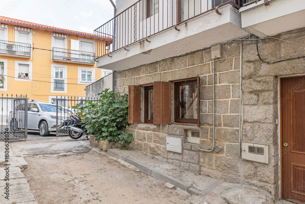 Fototapeta premium Main facade with a gray granite plinth and carved stone cornerstones, displaying the traditional construction elements of farmers' houses.