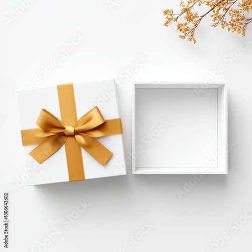 Elegant white gift box with golden ribbon bow from top view