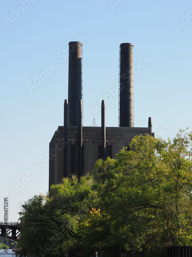 Industrial building facade with chimney pipes and bright sun flare