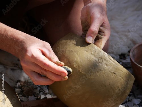 Foto Main d'une artiste produisant une poterie historique selon une méthode artisanal