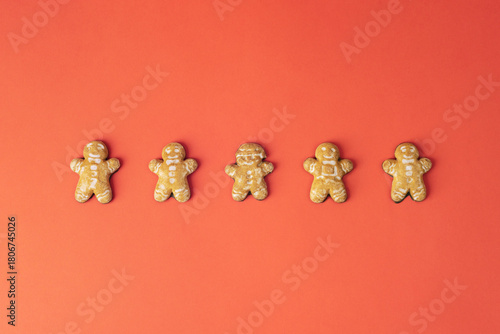 Gingerbread cookies in a row on red background. Sweet food, Christmas concept