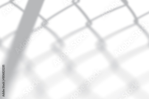 Shadow of chain-link fence creating dynamic shapes on white background for modern design