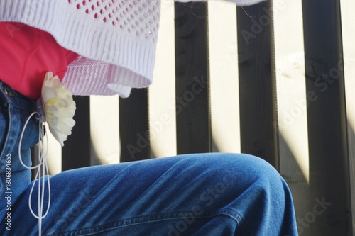 Cropped photo of a woman's leg in blue jeans bent at the knee. Fashionable women's clothing.