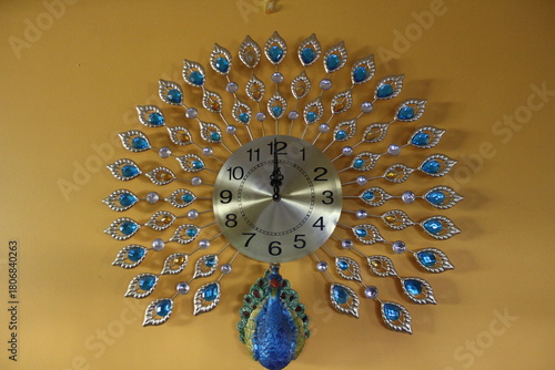 peacock shaped clock hanging on a yellow wall