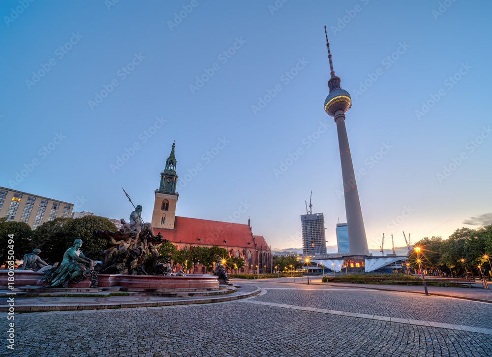 Obraz premium The Alexanderplatz in Berlin with the famous TV Tower and St. Marys church at dawn