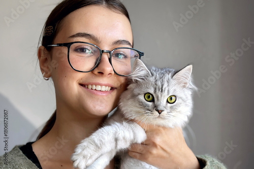 Beautiful smiling girl with a kitten. Young woman veterinarian holding cute white cat.