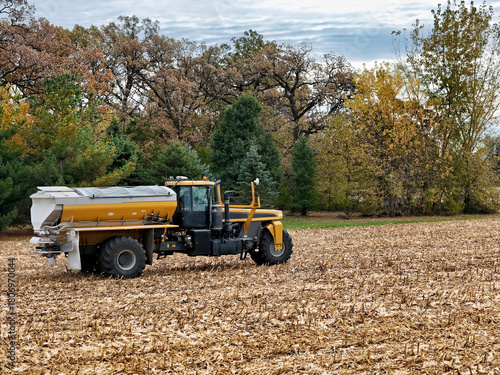 Self-Propelled Fertilizer Spreader in Autumn Cornfield Treating Post-Harvest Corn Stalk-Covered Field