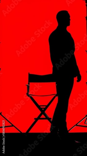 Silhouette of a Man in a Suit on a Red Background, Sitting on a Director's Chair, Dramatic Lighting