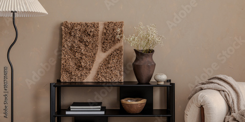 Minimalist interior with sculptural wall art, ceramic vase, and soft beige accents in a cozy modern living space.