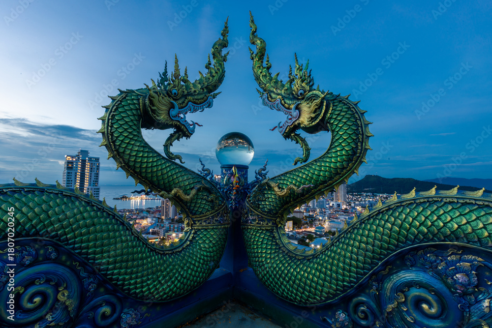 Fototapeta premium Background of Thailand's Chonburi religious attractions (Wat Khao Phra Khru viewpoint), with beautiful Buddha and Phaya Naga statues, tourists always come to make merit and take pictures at night.
