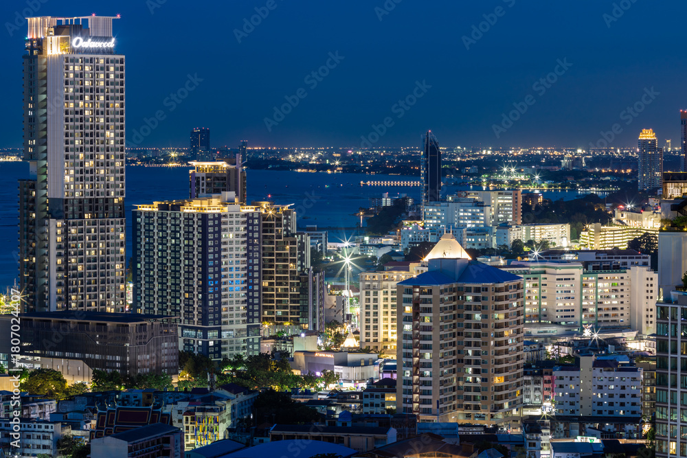 Fototapeta premium The high angle background of the city view with the secret light of the evening, blurring of night lights, showing the distribution of condominiums, dense homes in the capital community