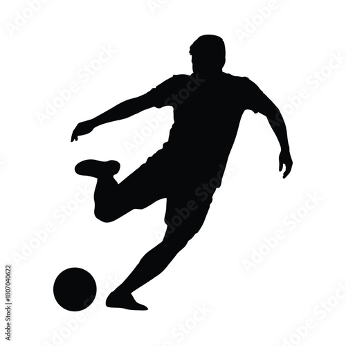 Silhouette of a soccer player kicking a ball in mid action