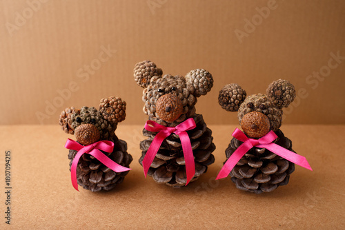 Handmade pinecone bears with pink ribbons, perfect for winter DIY, holiday crafting, eco-friendly decor, kids activities, and seasonal branding for gift shops or creative blogs