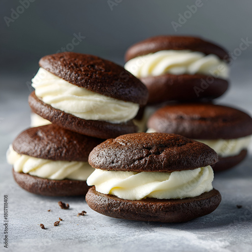 Stacked Brown Cookies display sweet vanilla frosting. Showcases baked goods, culinary presentations, and advertising.