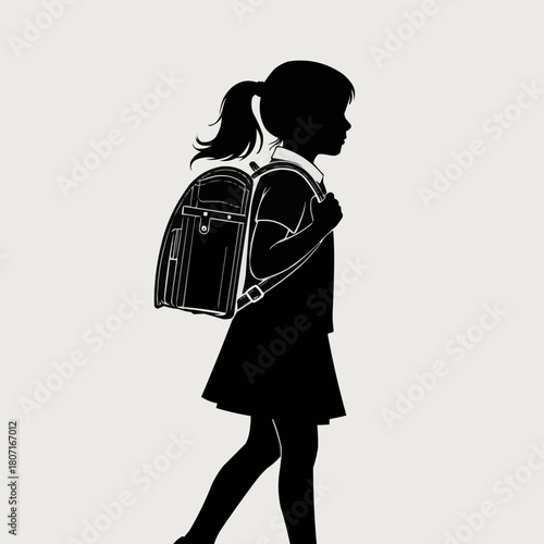 Silhouette of a young schoolgirl walking with a backpack.