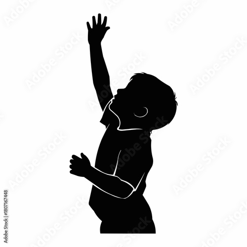 Black silhouette of a young boy reaching up high.