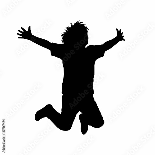 Black silhouette of a joyful young boy jumping high.