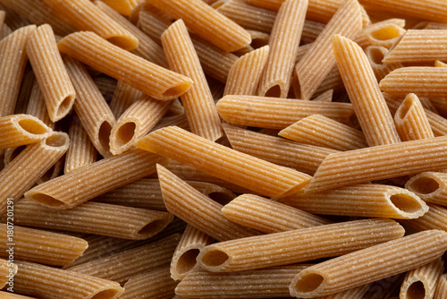 Organic whole wheat pasta,durum semolina flour macaroni,uncooked Penne rigate for background.