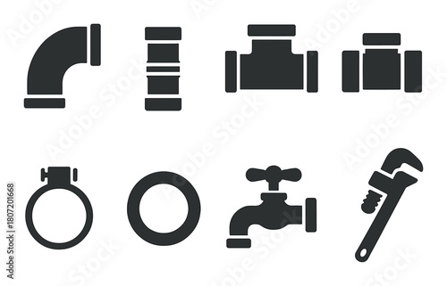 Different plumbing tools and pipe fittings on brown background